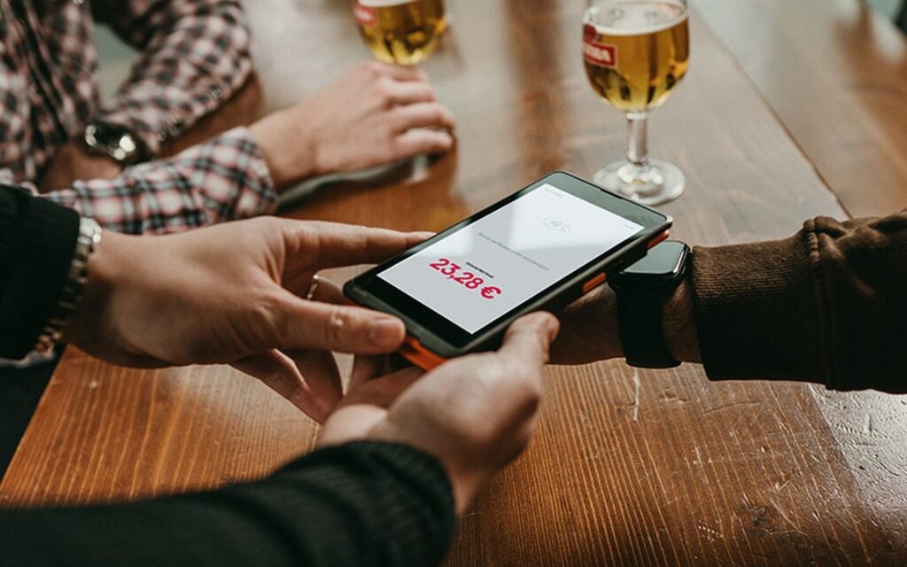 Unzer Kartenterminal bei der Zahlung am Tisch