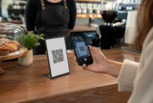 Kunde scannt einen QR-Code zum Bezahlen im Café